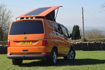 A campervan with a pop-top roof with solar panels installed