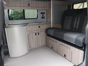 The inside of a campervan which has been converted to maximise space to fit more for less